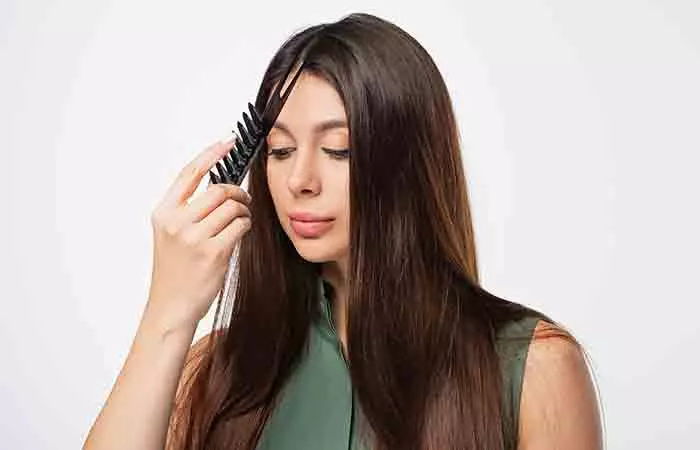  A woman parting her hair into small sections