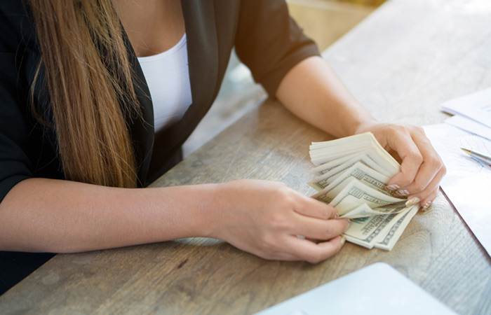 Woman counting cash for hair straightening treatment