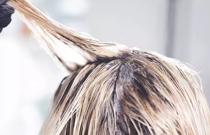 Close up of woman dyeing her bleached hair.