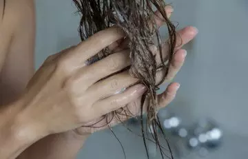 Woman using conditioner on hair