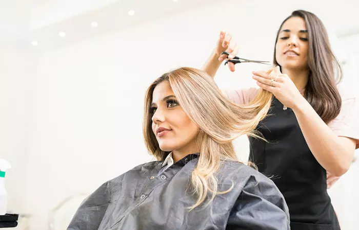 Close up of a woman getting a haircut at a salon.