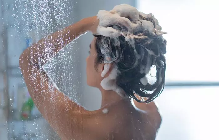 Woman washing her hair with shampoo