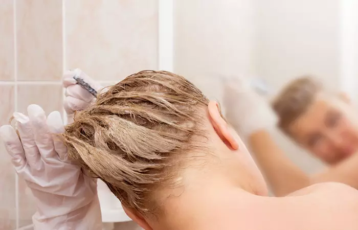 Backshot of woman dyeing her wet hair.