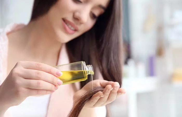 Woman applying canola oil to hair