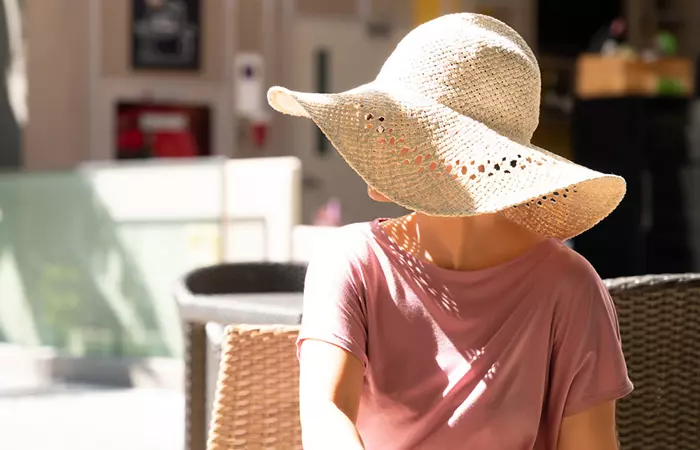 Woman wearing a wide rimmed hat to protect her hair from harsh weather and pollution