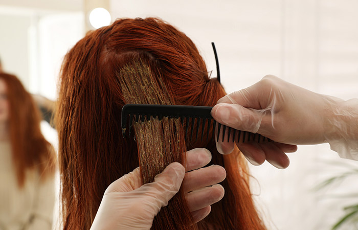 A girl with red hair getting her hair dyed 