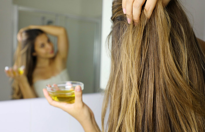 Woman using argan oil to keep her straightened hair shiny