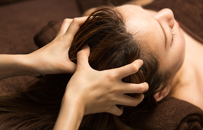 Woman getting scalp massage as acupressure for promoting hair growth