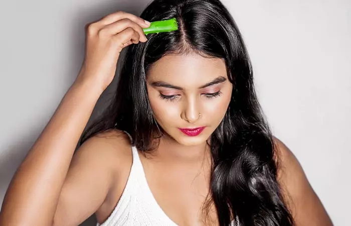 Woman applying aloe vera on hair