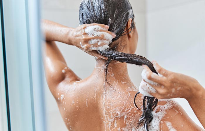 Woman washing her hair with liquid soap