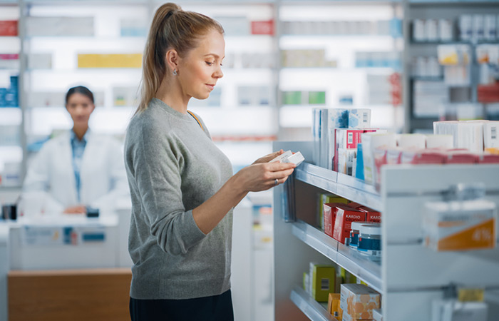 Woman buying MSM pills for hair growth at the drugstore