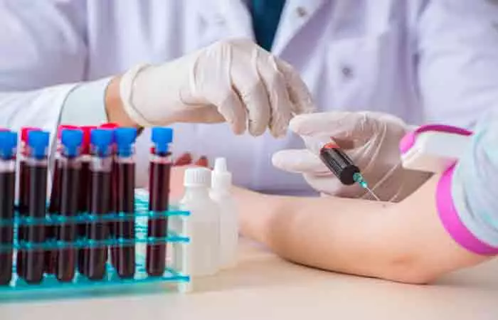 A medical professional taking a blood sample from a woman to test for underlying conditions that might cause thinning hair edges