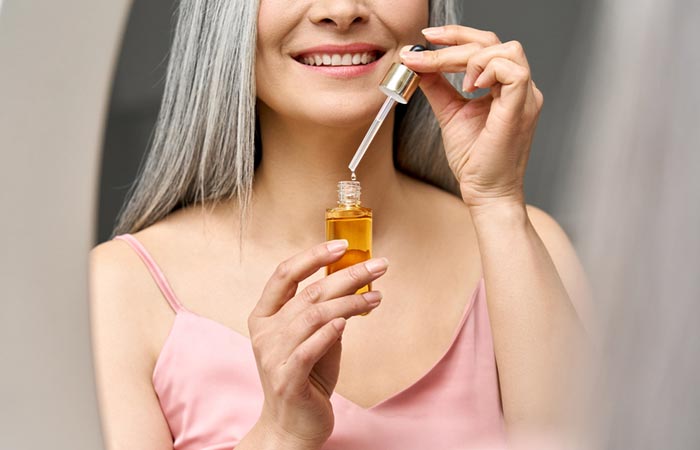 Woman applying essential oils to soften her gray hair