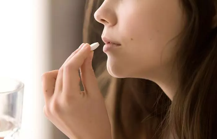 Woman taking prescribed oral silica supplement for hair 