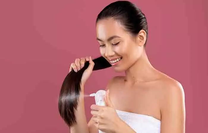 Woman using hair serum on hair.