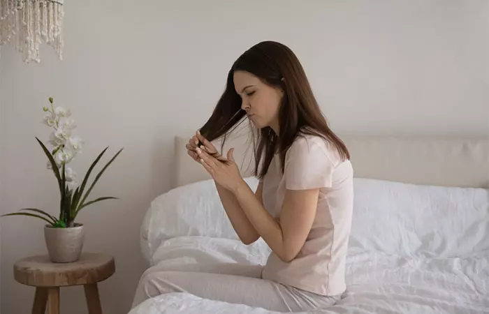 Woman looking at dull hair due to protein overload