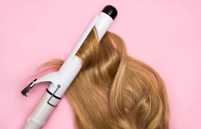 Woman applying heat styling tools on her hair