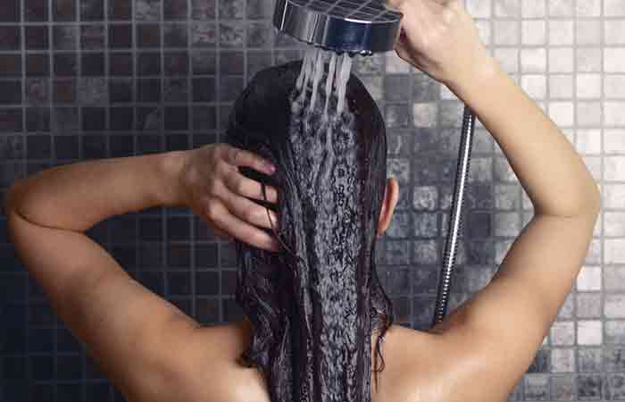 Woman rinsing hair with cold water