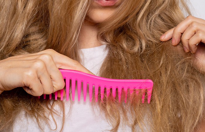 Woman combing rough hair caused by protein overload