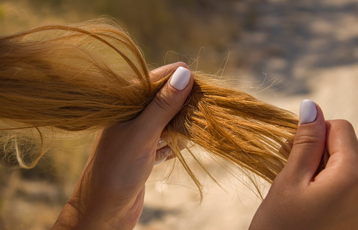 Woman holding her dry and frizzy fine hair