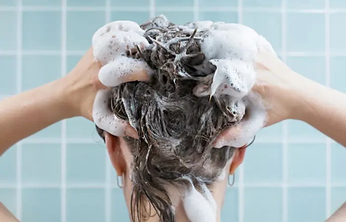 A woman with dish soap on her hair