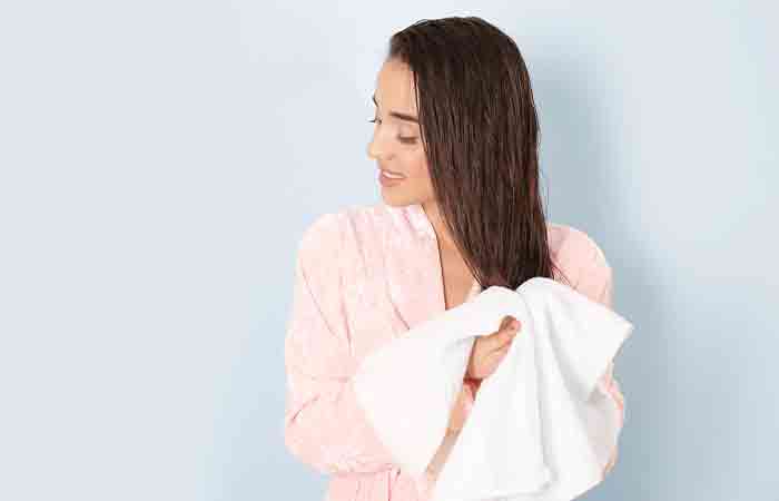 Woman drying her hair with a towel