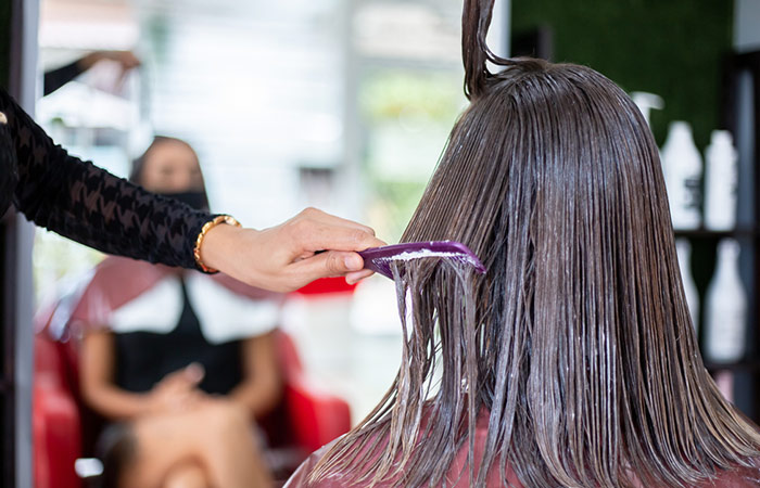 Woman getting a keratin hair treatment at a beauty salon