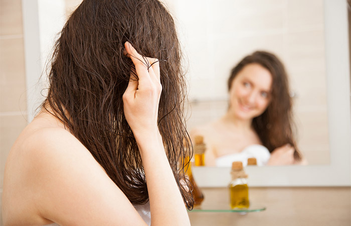 Woman applying castor oil in hair for dandruff 