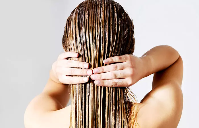 Woman applying an egg and chebe powder hair mask