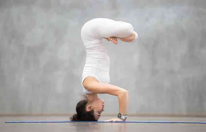 Woman performing yoga poses to increase blood circulation in the head and to balance her hormones