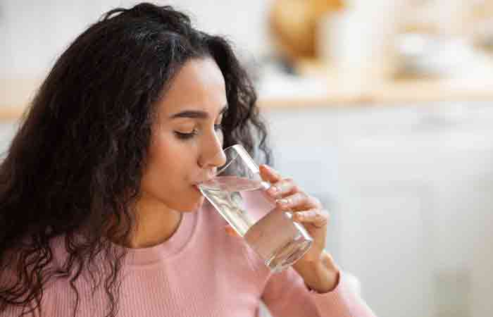 Woman drinking water for improved circulation and hair growth