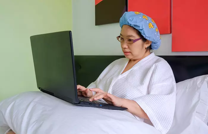 Woman working with shower cap to retain henna effect