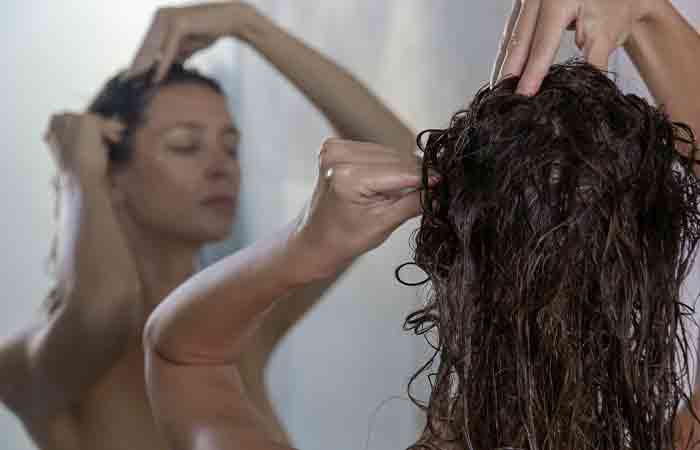 Woman massaging wet scalp for blood circulation