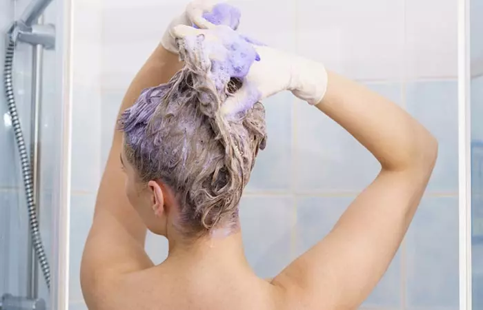 Woman using purple shampoo to maintain oil slick hair