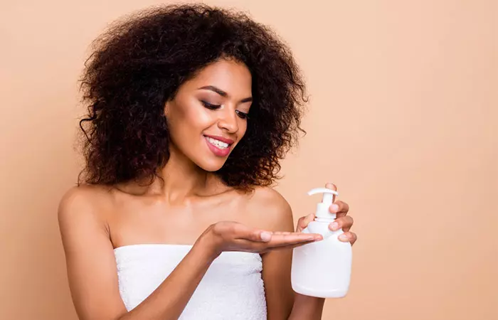 Woman styling curly hair with flaxseed gel