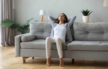 Woman relaxing on couch after applying ashwagandha oil