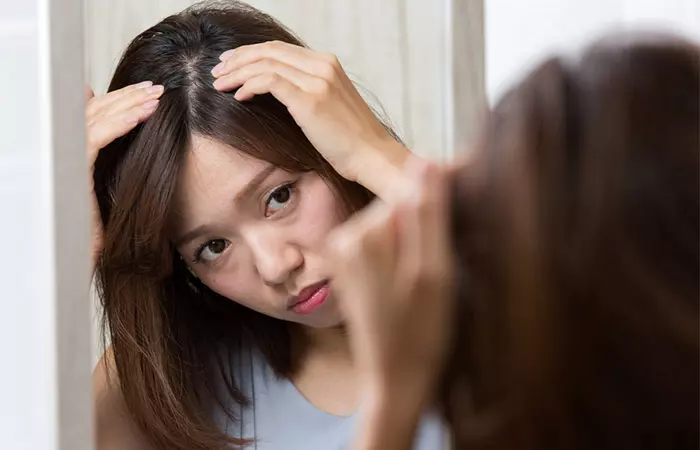 Woman checking for dandruff after applying ashwagandha oil