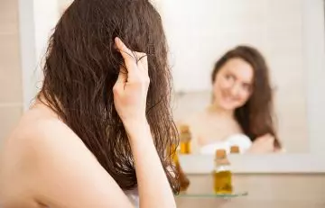Woman applying conditioner and chebe powder to her hair