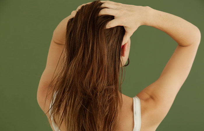 Woman applying evening primrose oil to scalp