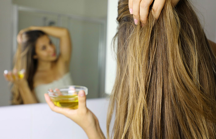 Woman applying olive oil to get rid of head lice