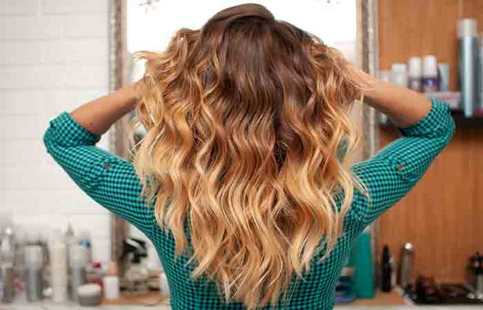 A girl is holding her ombre looking hair.