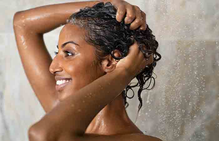 Woman washing hair to remove products