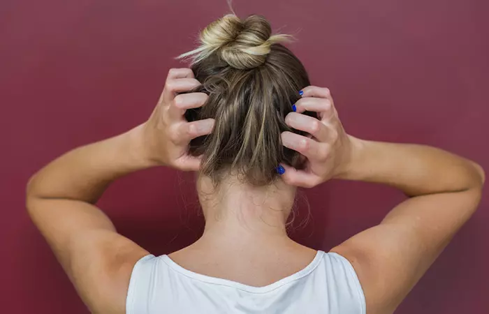 Woman scratching her scalp due to a mayonnaise allergy