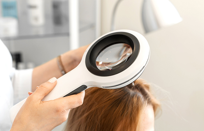 A trichologist examining a woman's hair
