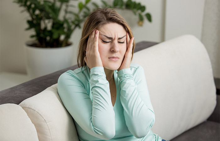 Woman having headache due to side effect of melanin supplements