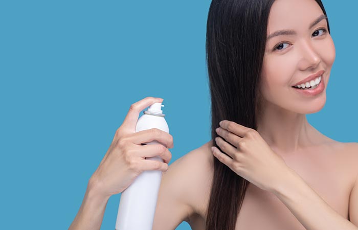 Woman applying SPF spray as part of Korean hair care routine