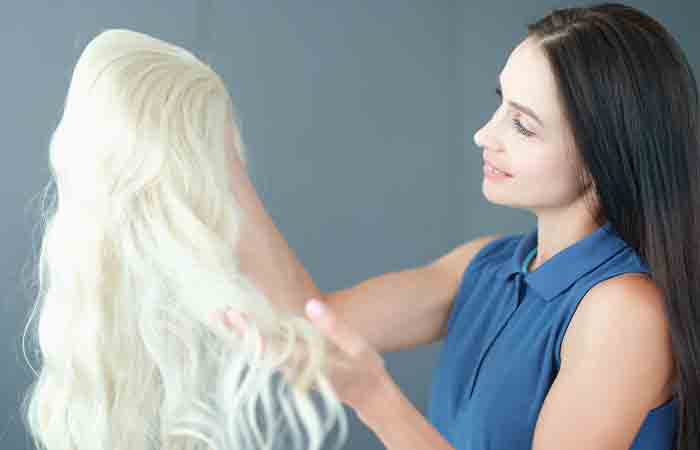 Woman holding a bleached synthetic wig