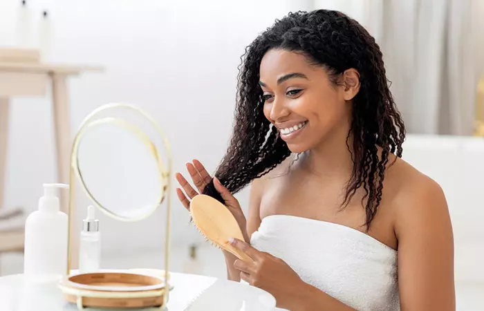 Woman combing her natural hair from the root tips