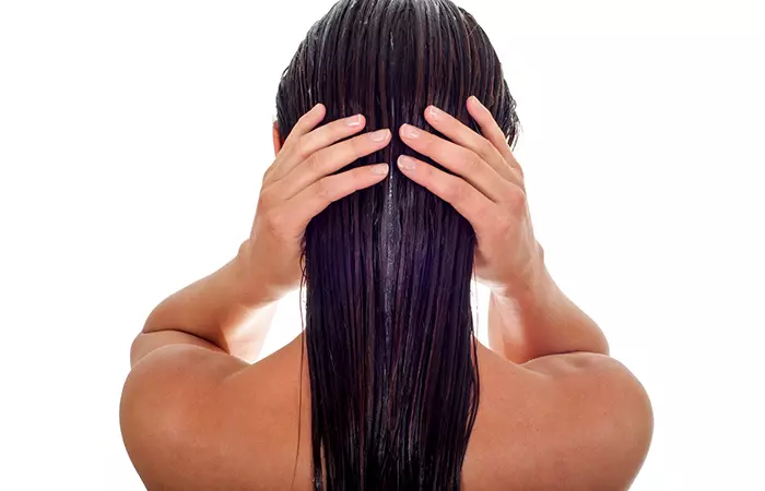 Woman conditioning her dyed hair to protect it from damage