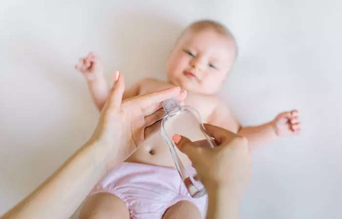 Mother oiling baby's scalp to prevent cradle cap